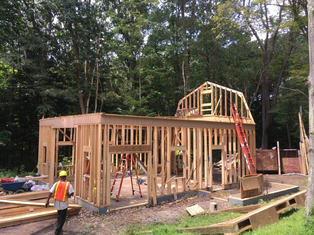 Further progress during the full structure deconstruction of a maintenance building at the Pittsburgh Botanic Gardesn, with only the framing of the first floor and one gable still standing.