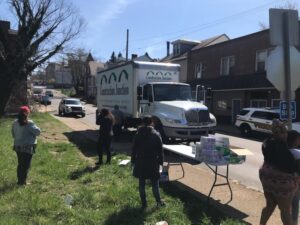 Image of Construction Junction's box truck arriving to drop off food and a neighborhood food distribution during the coronavirus pandemic.