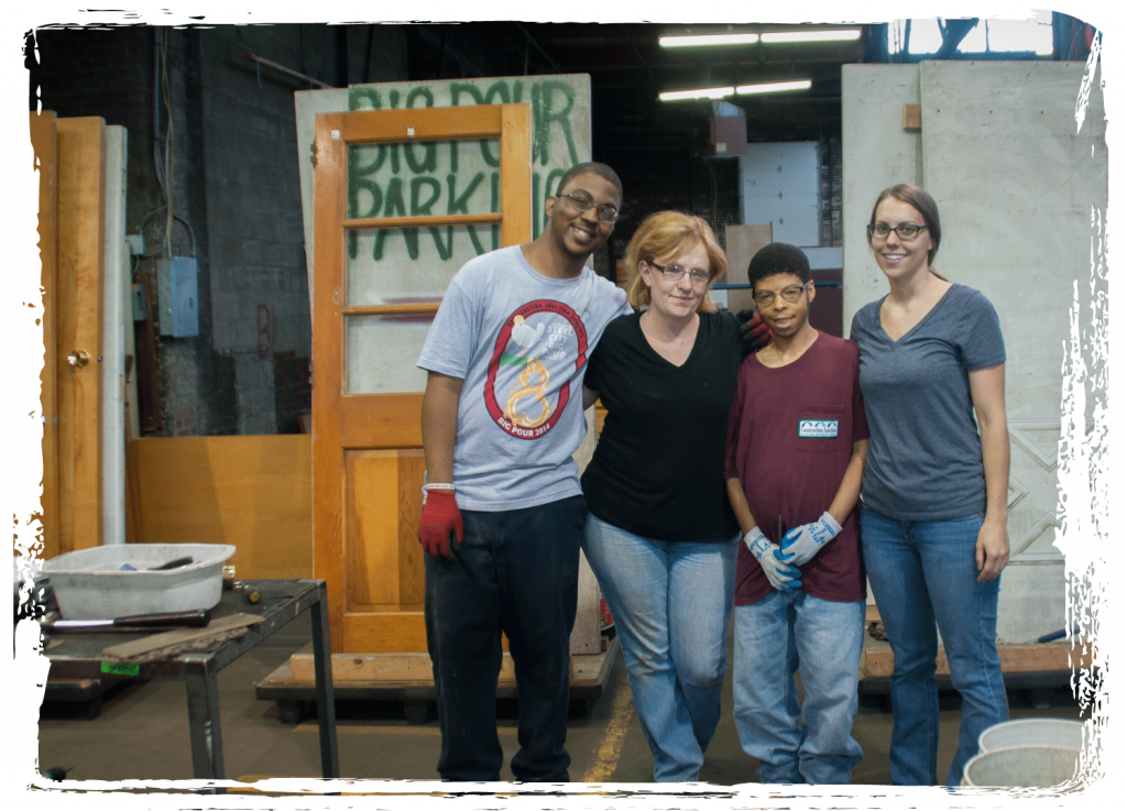 Goodwill instructors and trainees stand in the door processing area at CJ.