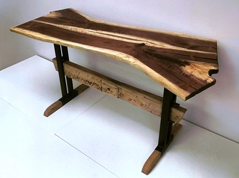 Live edge wood slab table with metal and wood trestle base crafted from reclaimed materials