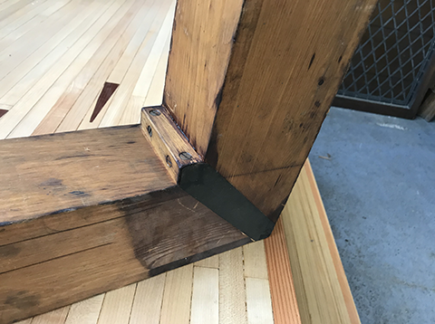 Close-up of a salvaged church organ pipe repurposed as an angled wood joint, showcasing the craftsmanship of reclaimed material reuse